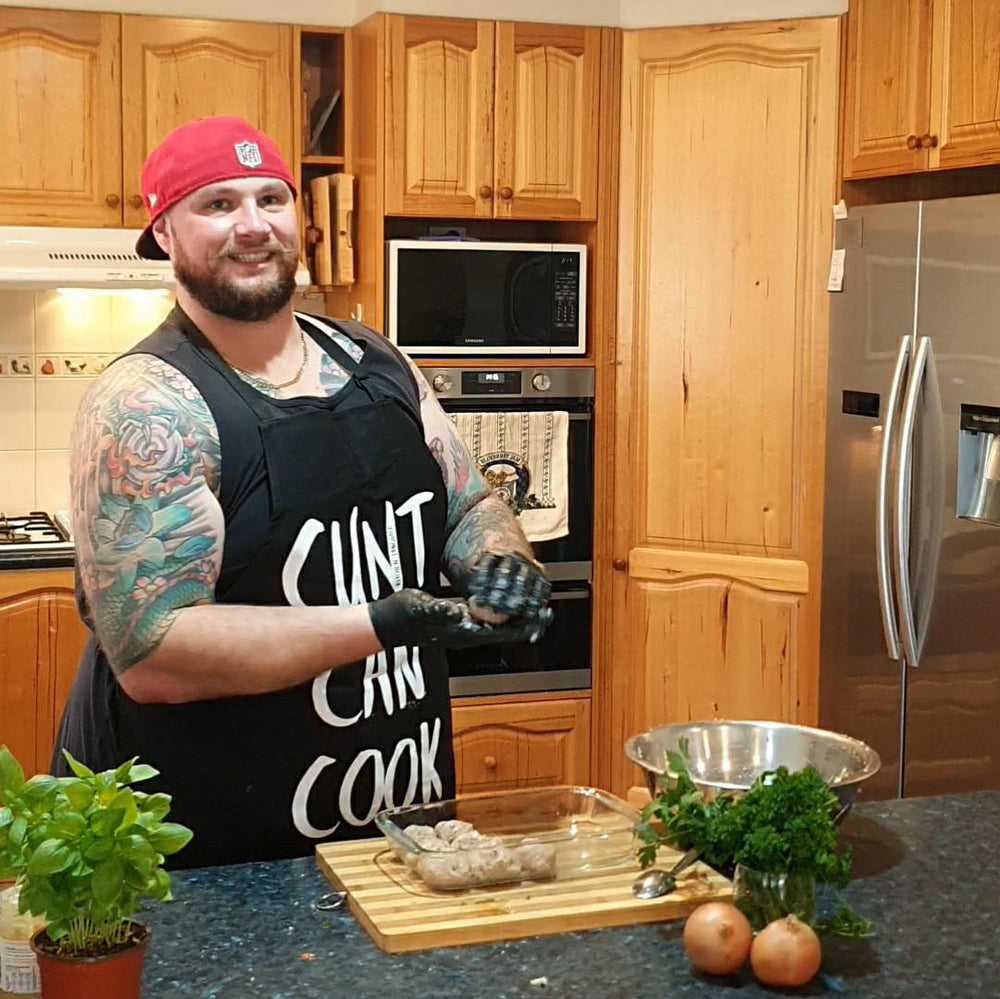 Cheeky Fella wearing Cunt Can Cook Apron in the kitchen