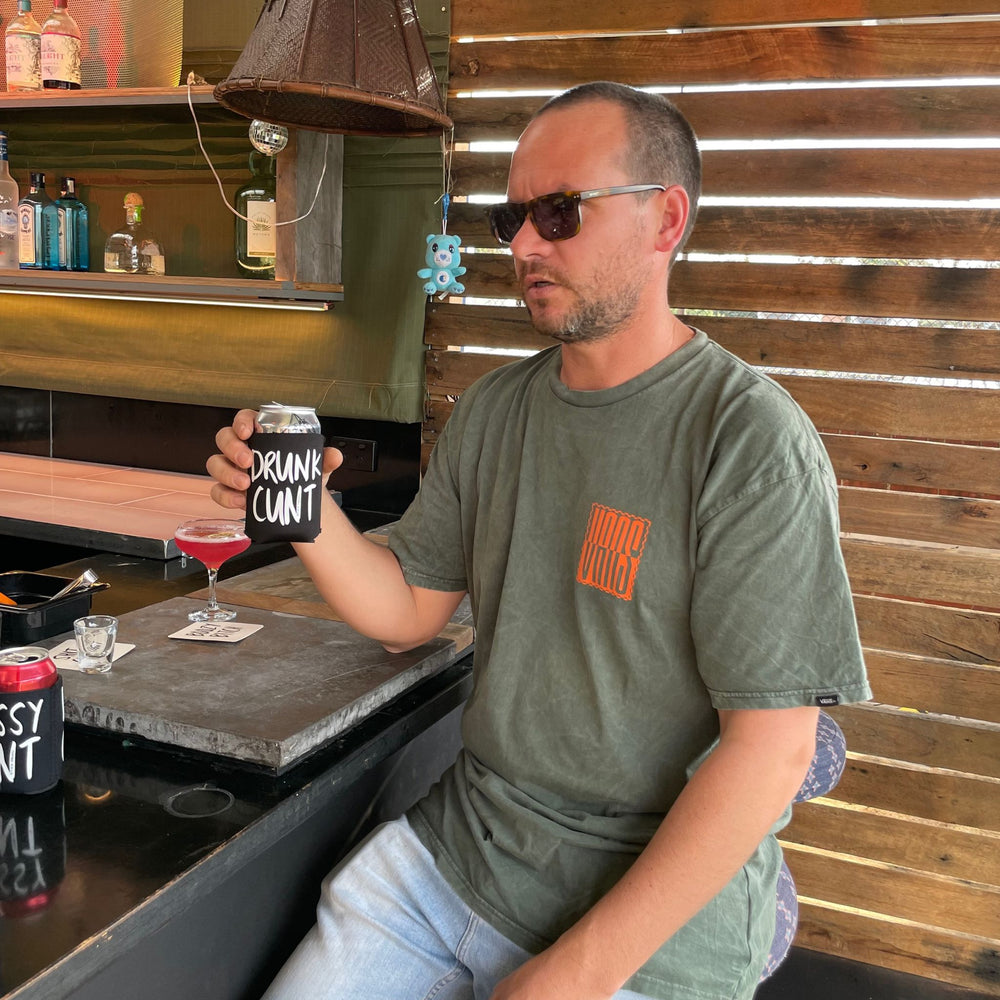 Man at bar with Drunk Cunt stubby holder